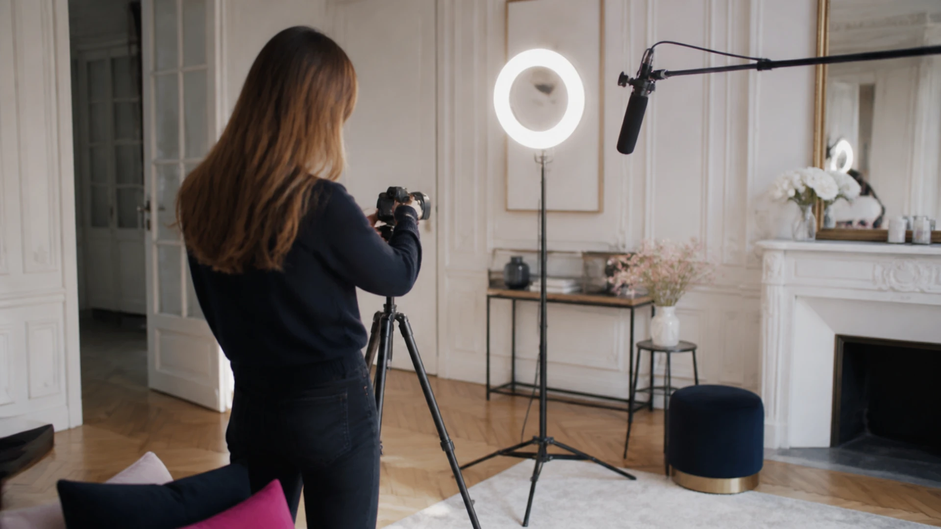 Créateur vu de dos réglant sa caméra dans un studio installé dans un appartement haussmannien