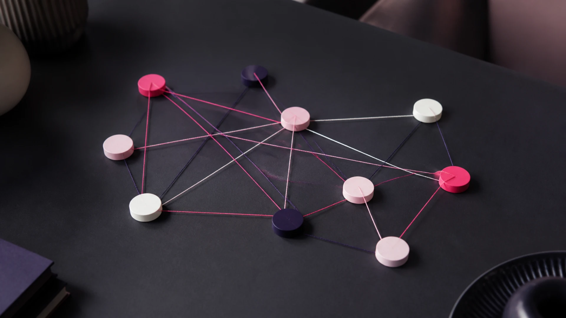 Jetons reliés par un réseau de cordons de couleur sur une table sombre