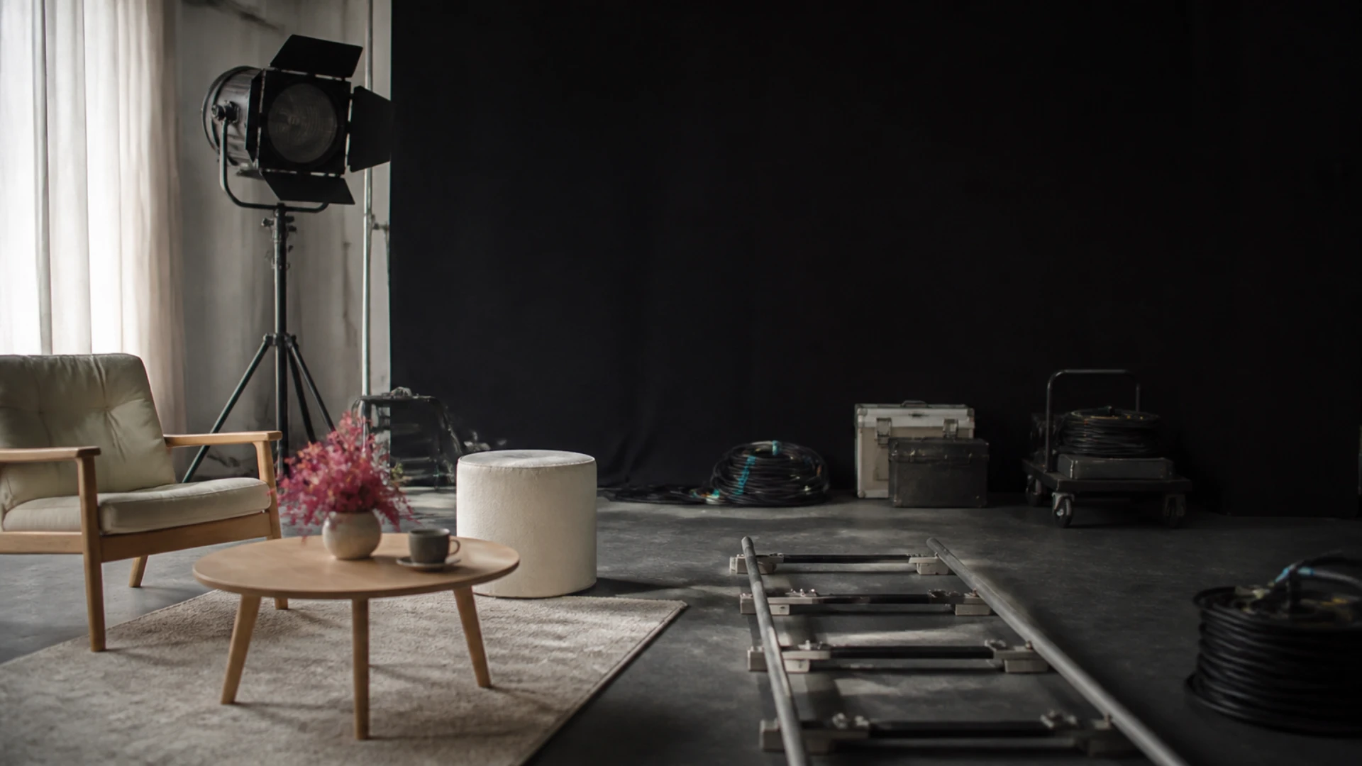 Projecteur de cinéma éteint et rails de travelling sur un plateau de tournage au repos