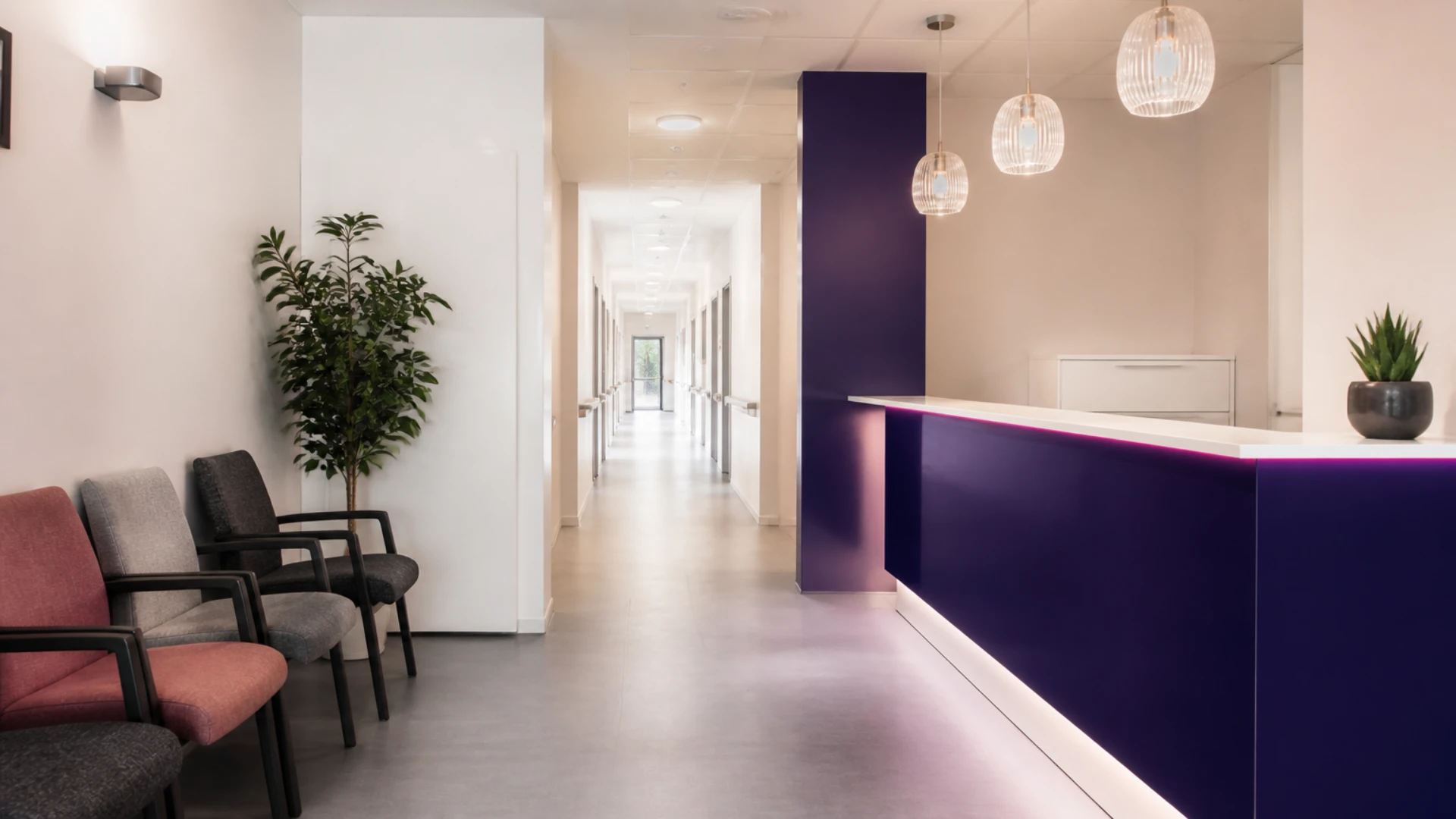 Hall d’accueil d’un établissement sanitaire et social avec fauteuils alignés et banque d’accueil