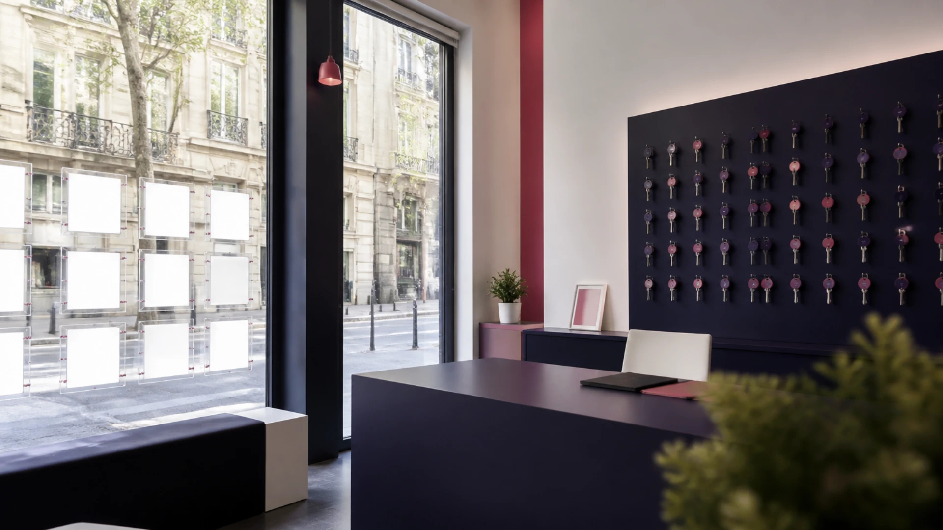 Intérieur d’une agence immobilière parisienne avec présentoirs vides et trousseaux de clés accrochés