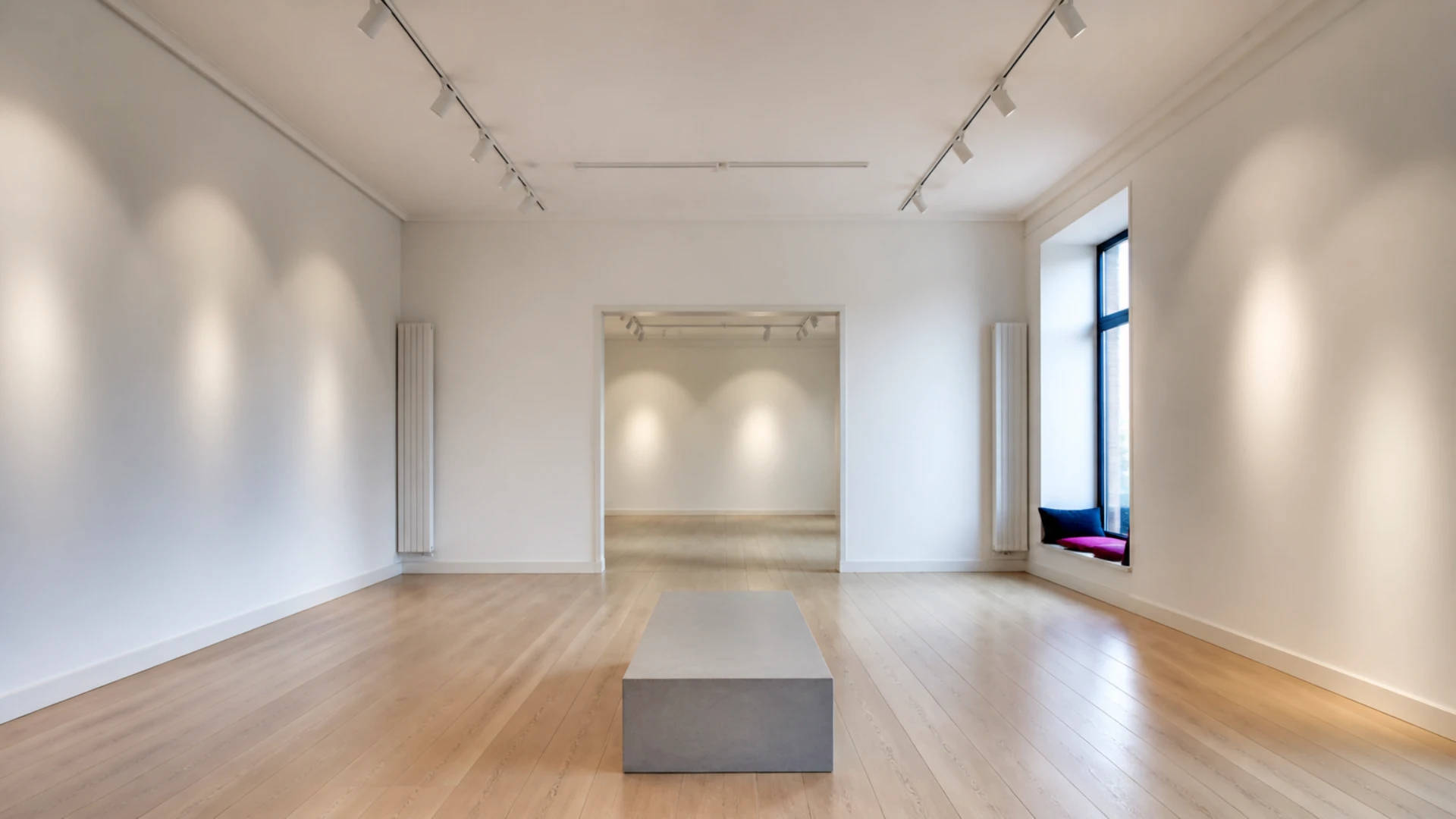 Galerie d'art vide aux murs blancs avec cimaises nues et spots allumés