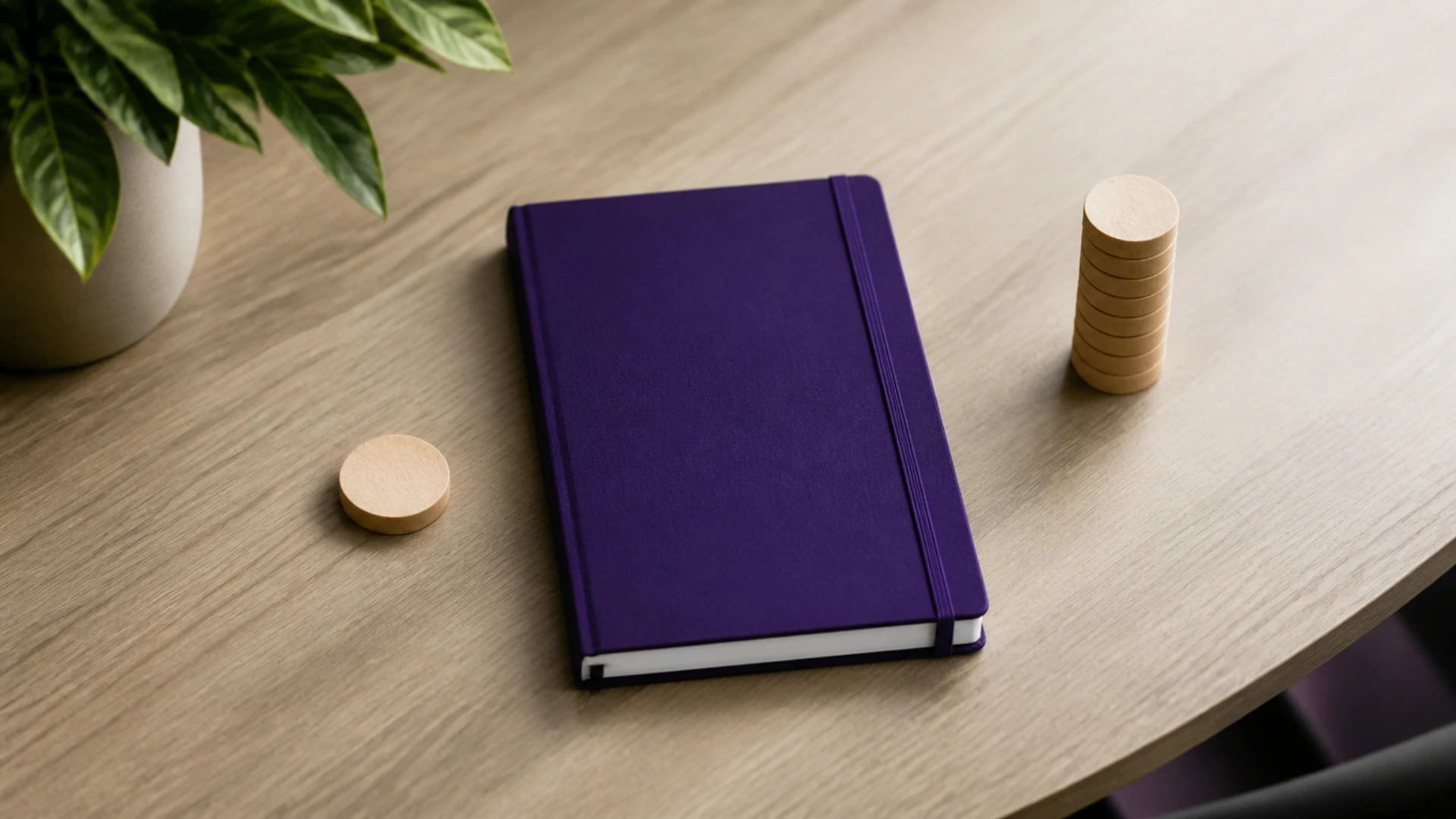 Carnet fermé, jeton isolé et colonne de jetons alignés sur une table de bois