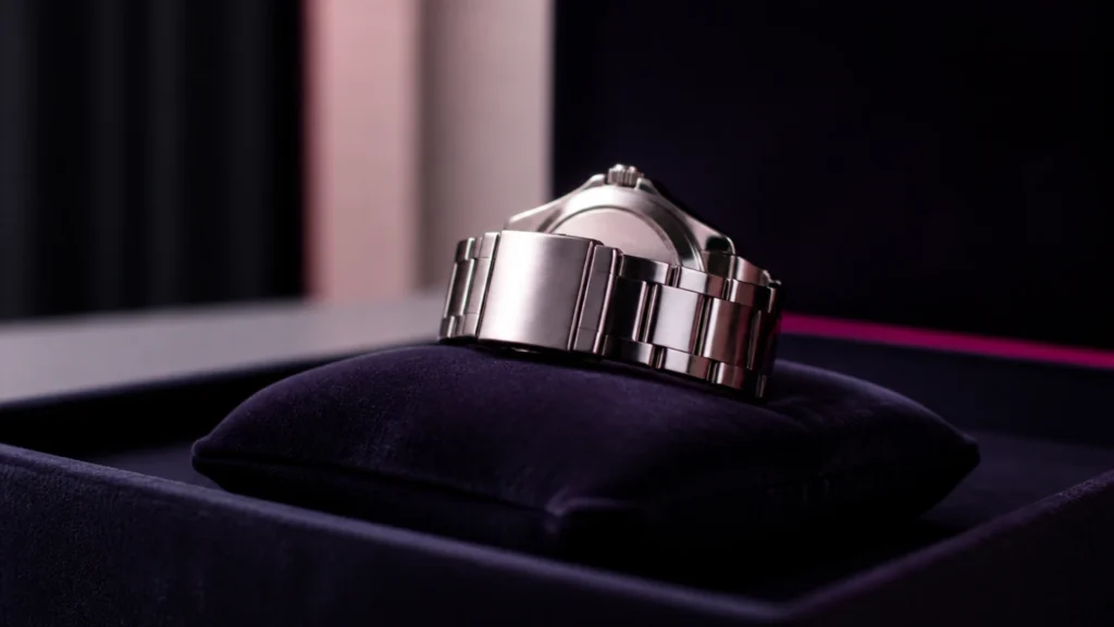Montre haut de gamme posée sur un coussin de velours, cadran non lisible