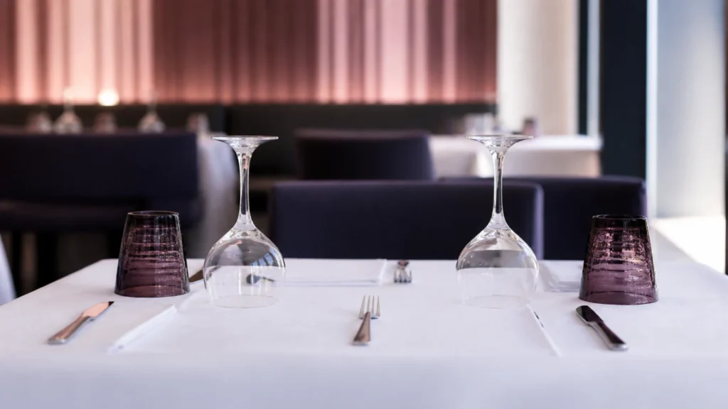 Table de restaurant dressée pour deux avec des verres à vin posés à l'envers
